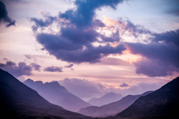 Sunlight lights the mountain peaks at sunset, Waterton Lakes National Park, Alberta, Canada.