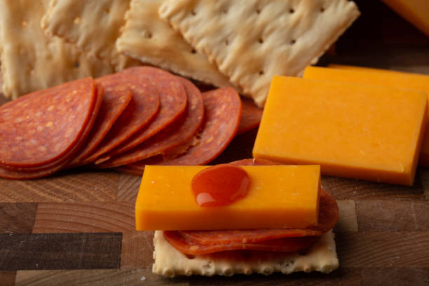salami-käse-cracker heiße soße - cheese portion cracker cheddar stock-fotos und bilder