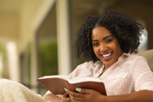 istock Happy woman reading and looking at the camera. 1126600540