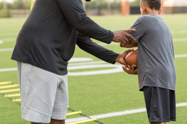 istock American Football coach training a young athlete. 1126600783