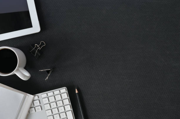 istock Office desk black leather table with computer, office supplies and coffee cup. Top view with copy space. 1126601562