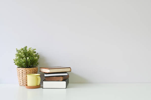 istock Copy space table a books, coffee and plant on white office desk. 1126601574