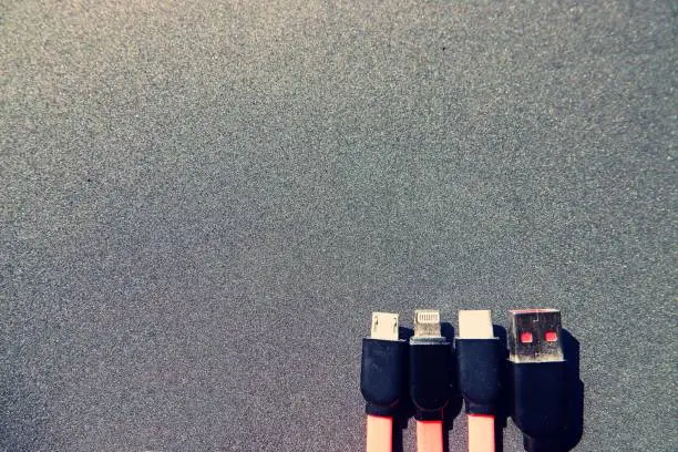 Photo of Four types of charging cables in front of black background with copy space