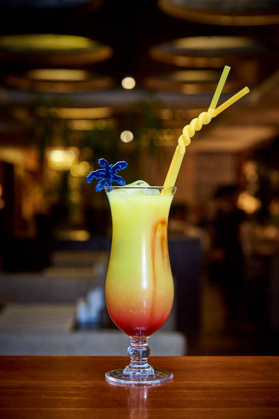Tropical cocktail on the bar counter on a dark blurred background.