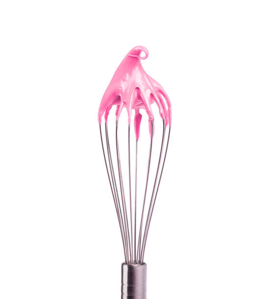 istock Metal whisk with pink cream isolated on white background. Clipping path. 1126610932