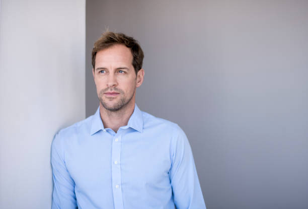 istock Handsome mid adult businessman leaning on wall 1126613948