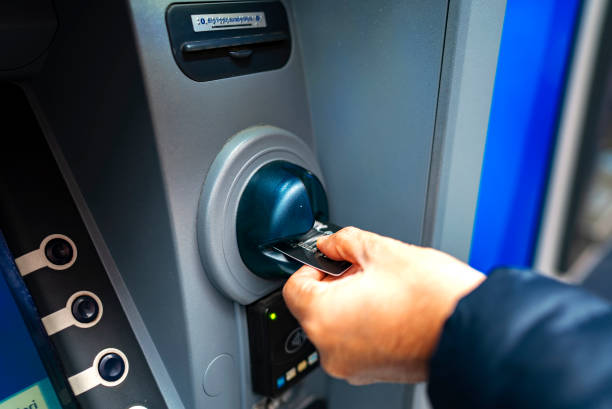 istock man pushing credit card at cash dispenser 1126616103