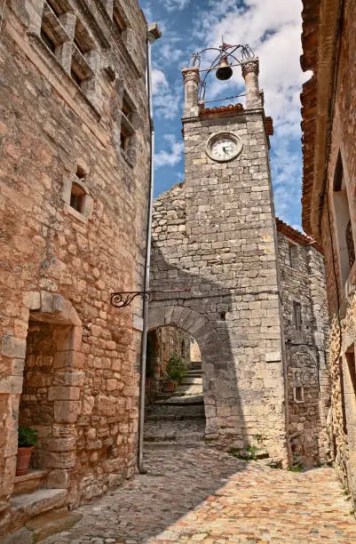 Lacoste, Vaucluse, Provence, France: the bell and clock tower in the old town of the picturesque medieval village