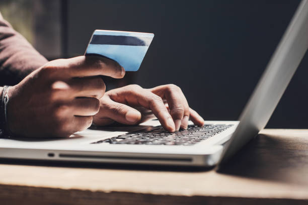 hombre de compras en línea con el ordenador portátil y tarjeta de crédito - online shopping fotografías e imágenes de stock