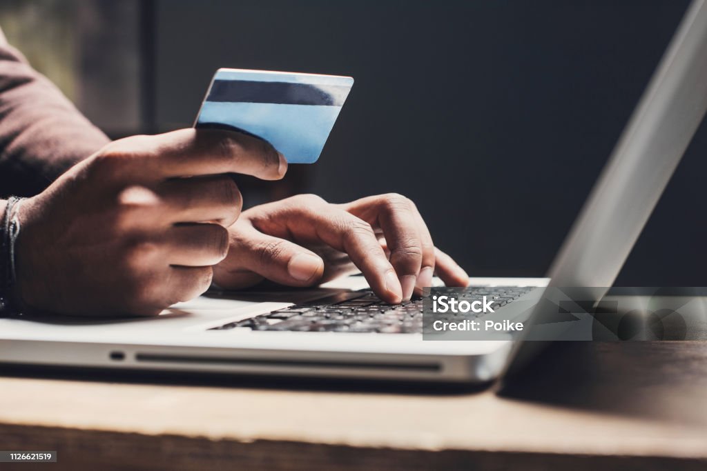 Man shopping online using laptop computer and credit card Men entering credit card information using laptop computer keyboard. Online shopping concept Credit Card Stock Photo