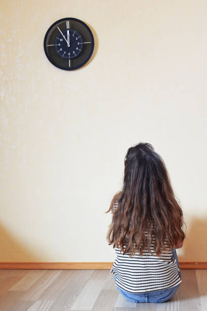 dziewczyna siedząca na podłodze i patrząca na zegar - waiting women clock boredom zdjęcia i obrazy z banku zdjęć