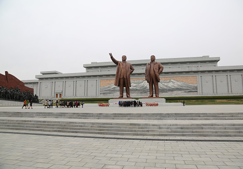 April 13, 2018. Pyongyang, North Korea.\nKim Il-Sung and Kim Jong-Il have special posters and monuments in different parts of the city. The most important of these monuments is the giant sculptures of North Korea's founding leader Kim Il-Sung and his son Kim Jong-Il. All tourists who come to visit the country have to come here and show their respects.