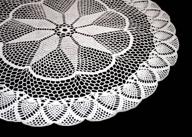 istock A part of isolated crocheted white doily with pattern with cones and arches a black background. Round decorative cotton doily. 1126626912