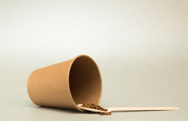 istock paper coffee cup empty lies on a light background, next is a wooden spoon with coffee 1126628114