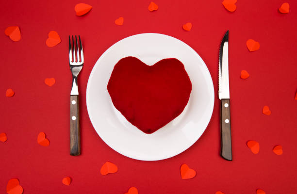 istock Heart on a plate for dinner. A romantic evening with hearts on red background 1126628221