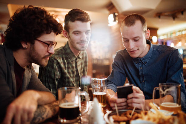 istock Friends drinking in the bar and using phone 1126628500
