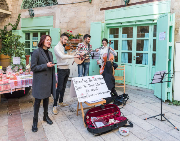 eine gruppe von jungen künstlern führen weihnachtslieder auf der auf der straße der stadt nazareth in israel - nazareth israel stock-fotos und bilder