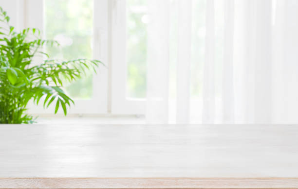 piano tavolo in legno su sfondo sfocato di mezza finestra con tende - pianale da cucina foto e immagini stock