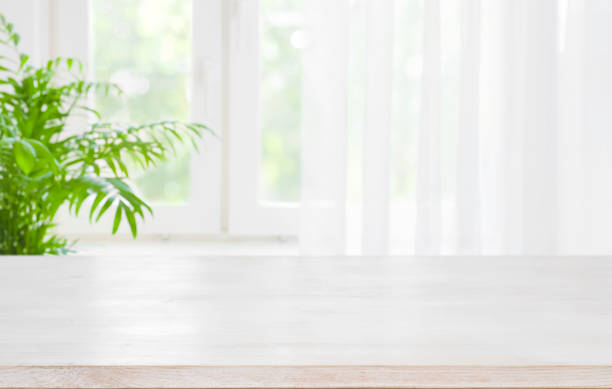木製テーブルの上にぼやけて背景カーテン半分の] ウィンドウ - 植物 ストックフォトと画像