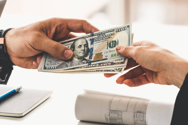 Transfer of money from hand to hand. Businessman hand sending money to another business person. Transaction, payment, salary and banking concept. bribing stock pictures, royalty-free photos & images