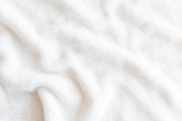 ぬいぐるみ生地の白い繊細な柔らかい背景。ツイストの襞とベージュの柔らかいフリース毛布の繊維の質感。 - タオル ストックフォトと画像