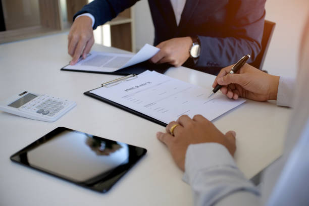 istock Sales manager giving advice application form document, considering mortgage loan offer for car and house insurance. 1126639838