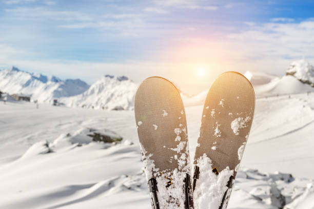 close-up pair of skis on mountain winter resort with ski-lift and beautiful winter mountain panoramic scenic view - ski resort winter sport apres ski ski slope imagens e fotografias de stock