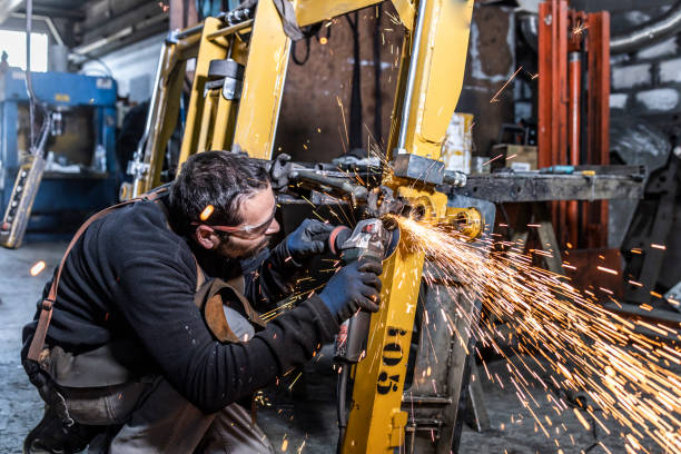 young worker with a sander machine in a factory - grinding grinder work tool power tool imagens e fotografias de stock