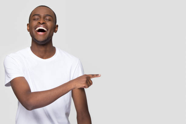 istock Happy african man laughing pointing finger aside at copy space 1126648993