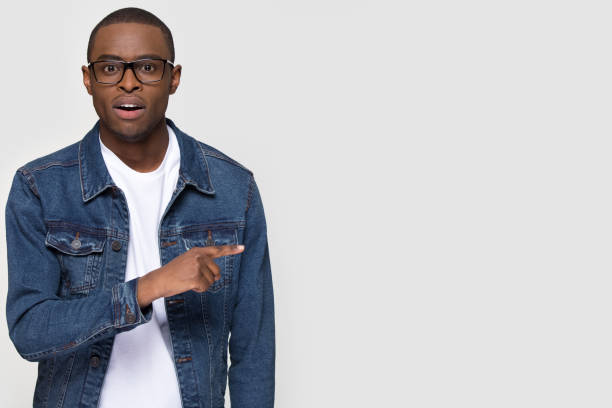istock Shocked african man student pointing finger aside at copy space 1126648999