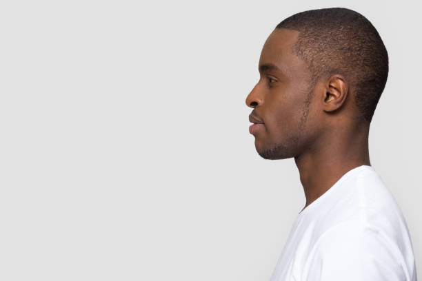 istock Millennial african man standing in profile isolated on white background 1126649019