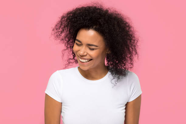 Happy african american girl laughing isolated on pink background Happy young african american mixed race girl laughing at funny joke isolated on pink blank studio background, cheerful millennial black woman having fun enjoy sincere positive emotions and laughter child laughing hysterically stock pictures, royalty-free photos & images