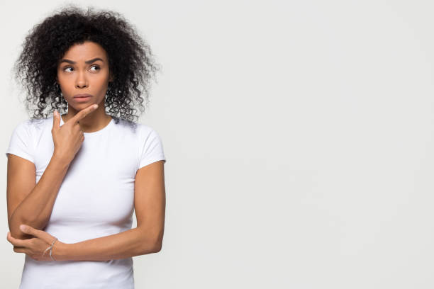 istock Thoughtful african woman holding hand on chin looking at copyspace 1126649066