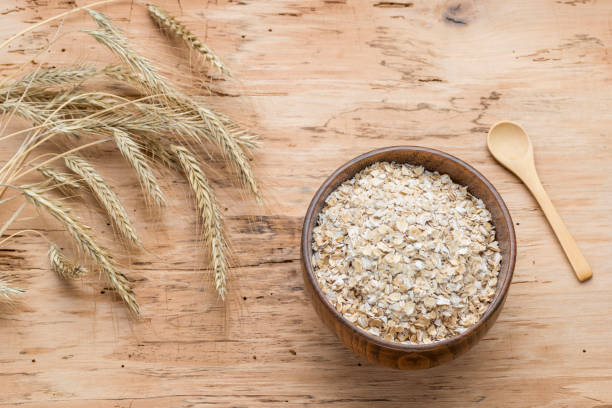 istock Oat flakes in wood bowl on oak table, rustic style 1126651015