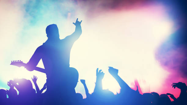 istock Man playing guitar at the stage, crowd cheering. 1126651300