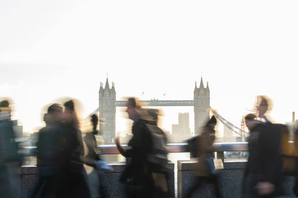 バック グラウンドでタワー ブリッジとロンドン ブリッジ英国の仕事に歩いて通勤のモーション ブラー ショット - tower bridge uk london england people ストックフォトと画像