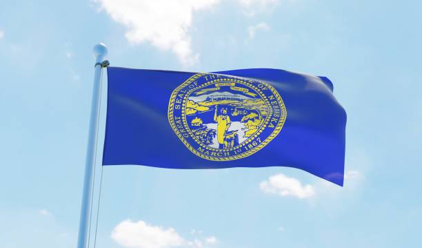 istock Nebraska (USA) flag waving against blue sky 1126656065