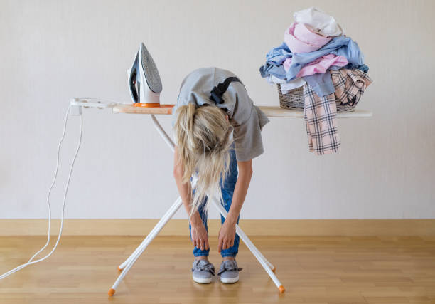 istock Exhausted woman lying on ironing desk 1126657050