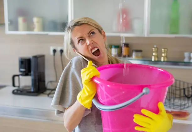Photo of Angry woman calling for help because of water leak at home
