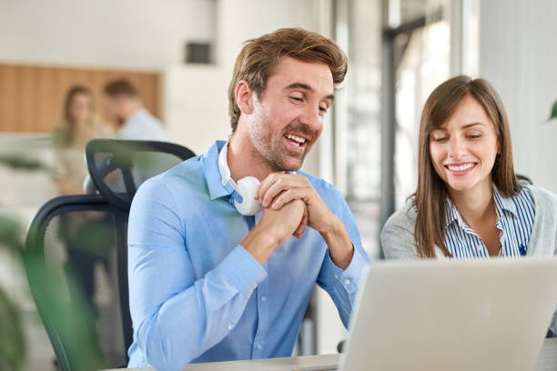 istock Two colleagues sitting at office and using laptop. 1126659402