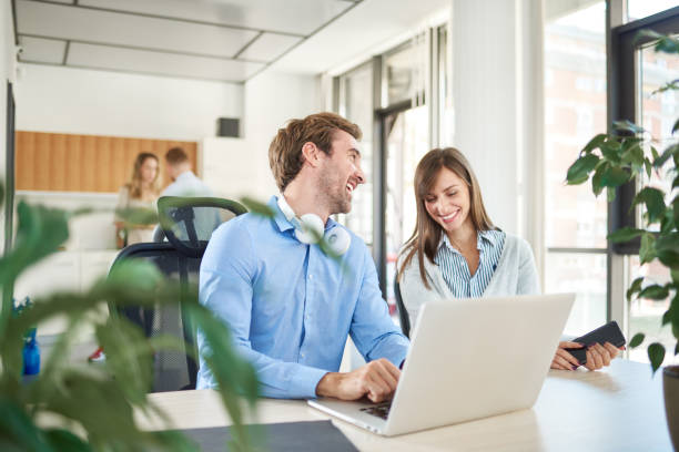 istock Two colleagues sitting in office and working on laptop. 1126660553
