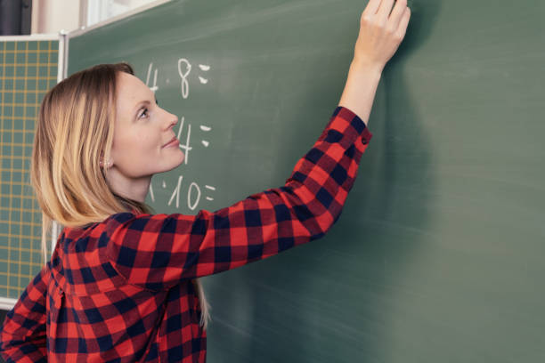istock Attractive woman maths teacher writing on a board 1126662514