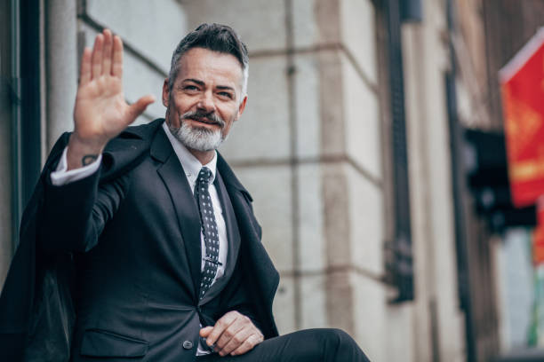 istock Handsome mature gentleman in suit waving 1126663548