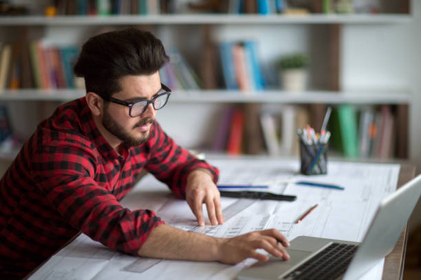 istock Architect man holding pencil working with laptop 1126666281