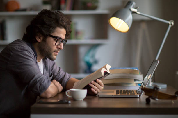 man reading book on the table - house pen people caucasian imagens e fotografias de stock