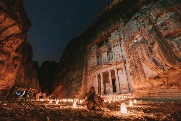 istock Woman looking at Petra by night 1126671124