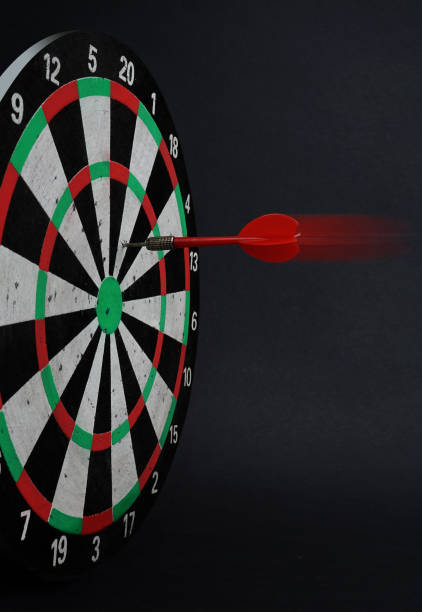 istock Dart arrow hitting on center target of dartboard. 1126680203