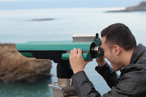 Tourist using a telescope during a vacation.