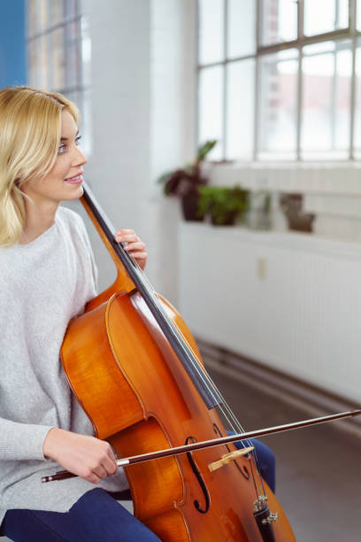 istock Smiling cellist holding her instrument and bow 1126684926