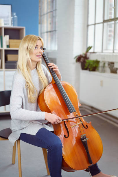 istock Beautiful young cellist sits in living room 1126684971